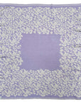 Personalisierte lilimoon Babydecke gestrickt aus Baumwolle mit Kaschmir in Flieder und Cremeweiss mit Blütenmuster.