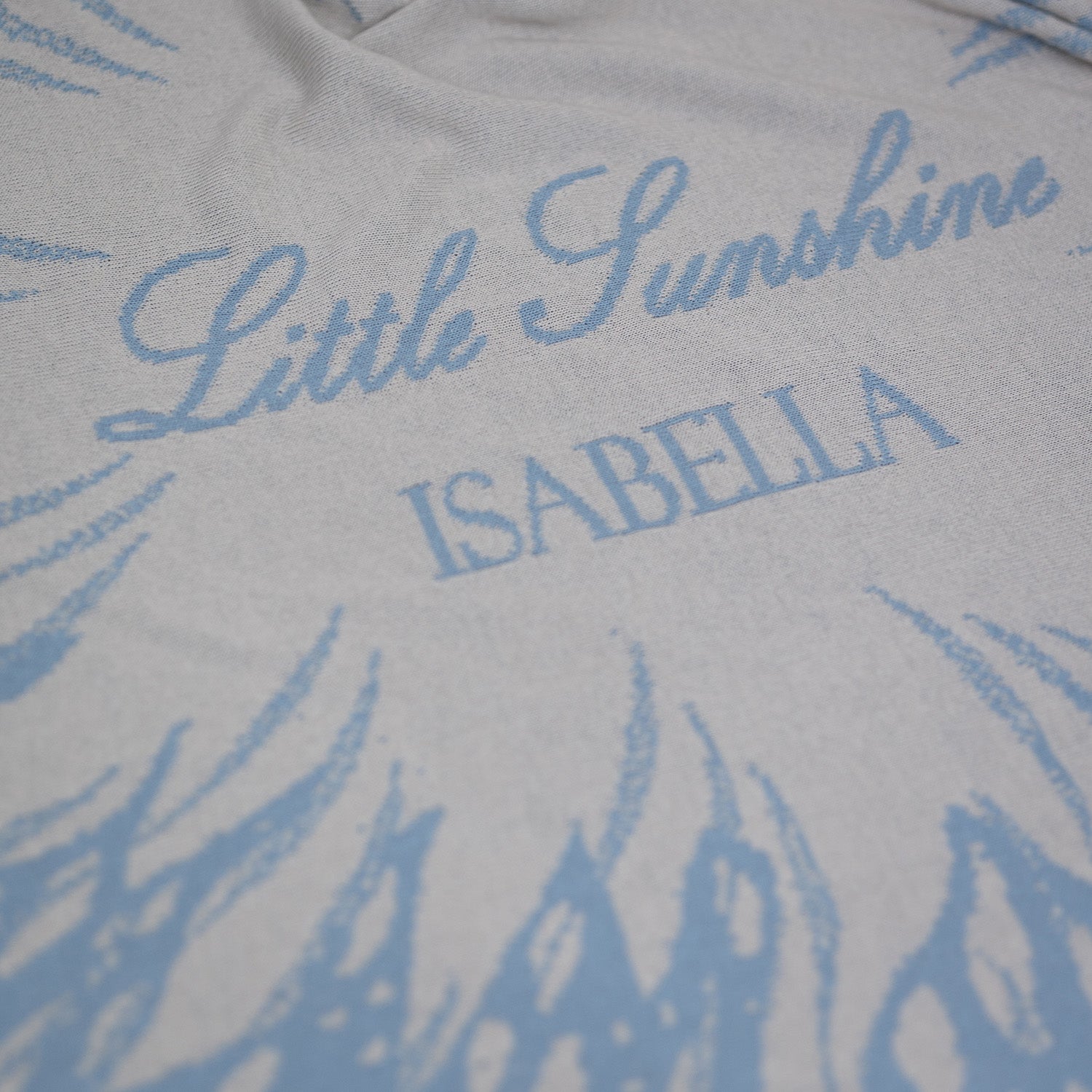 Detailaufnahme der personalisierten Babydecke SUNSHINE mit eingestricktem Namen von LILIMOON