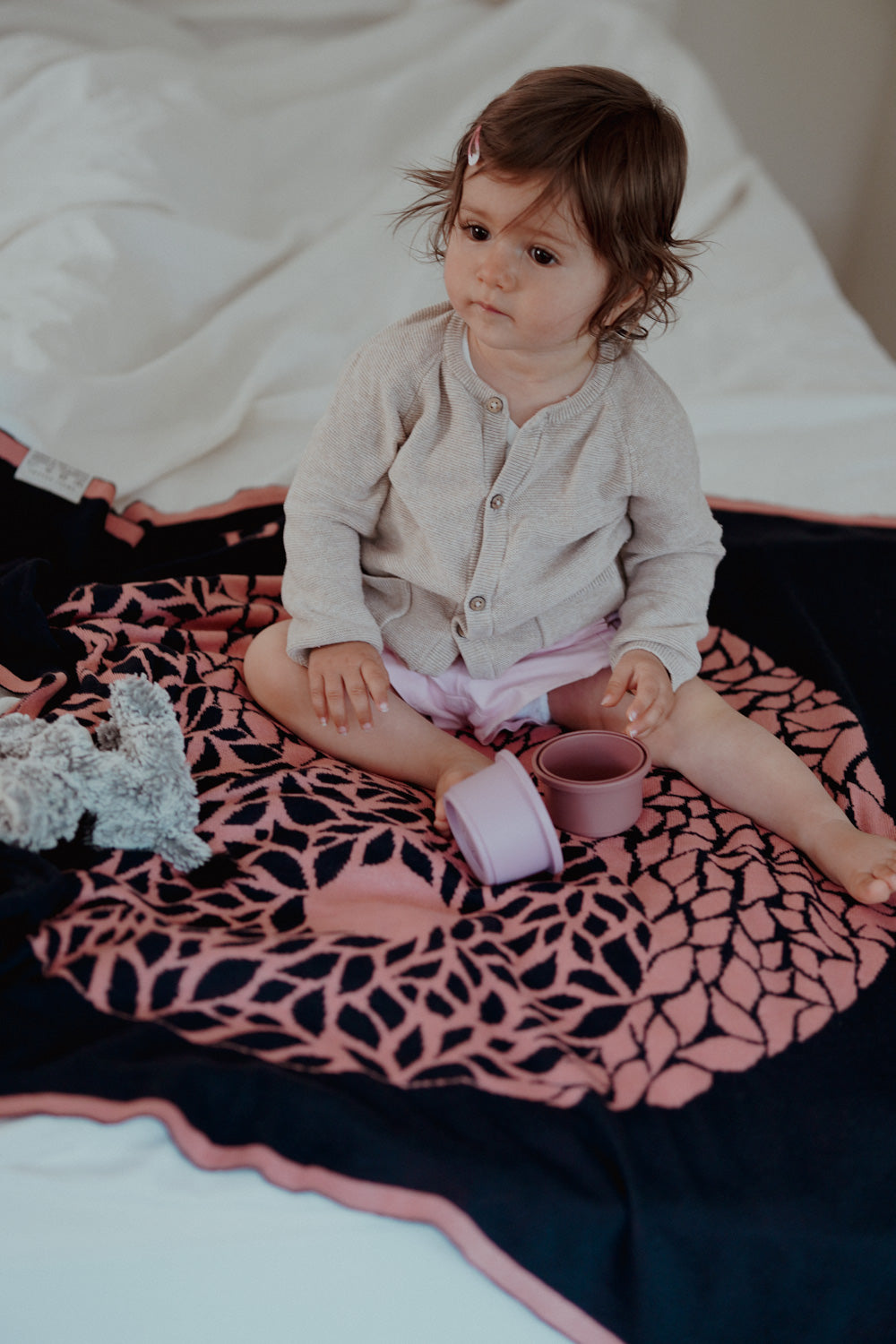 Kleinkind sitzt auf der personalisierten Babydecke YIN YANG von LILIMOON